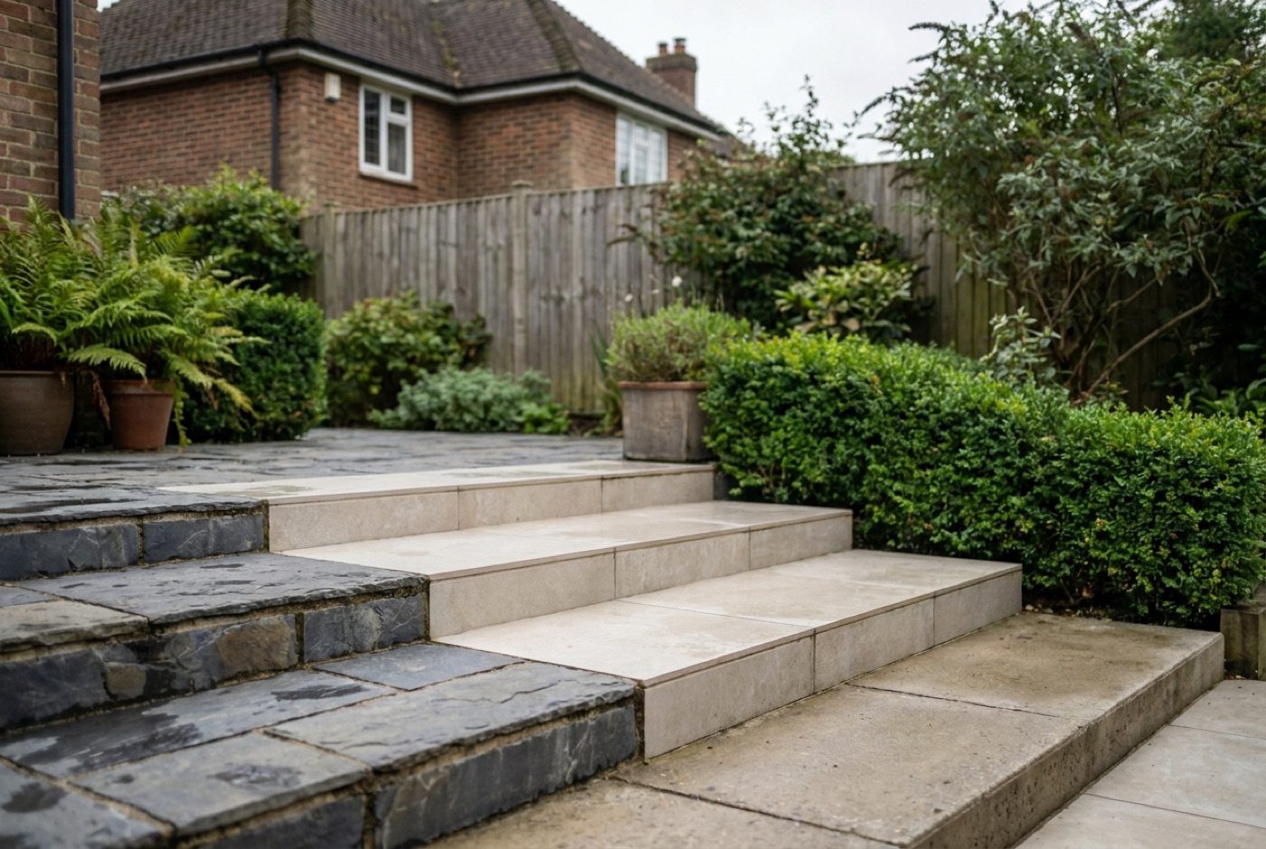 Three step samples side by side — riven natural stone, a porcelain paver and a cast concrete step
